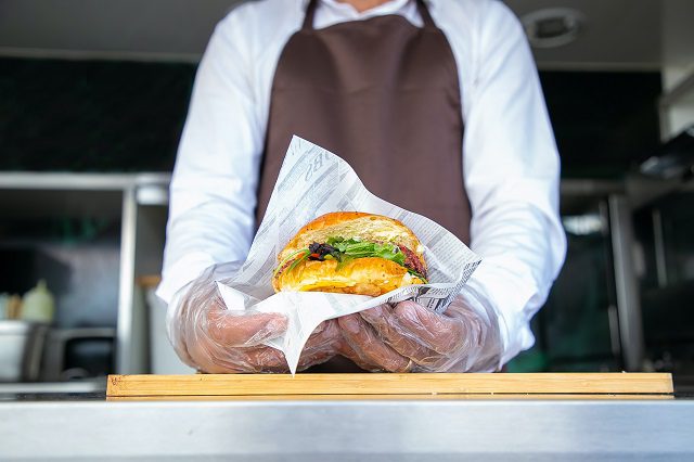 Person holding a sandwich in a food truck