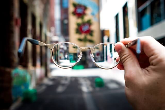 Close up of person holding glasses in outdoor setting