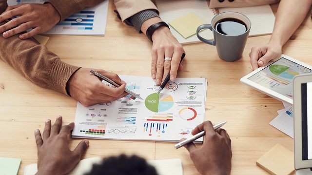 Group planning session at table with graphs in the center